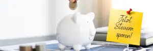 Sparschwein in weiß mit einem Post it: Jetzt Steuern sparen!